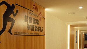 A hotel hallway with wooden paneling and a carpeted floor.