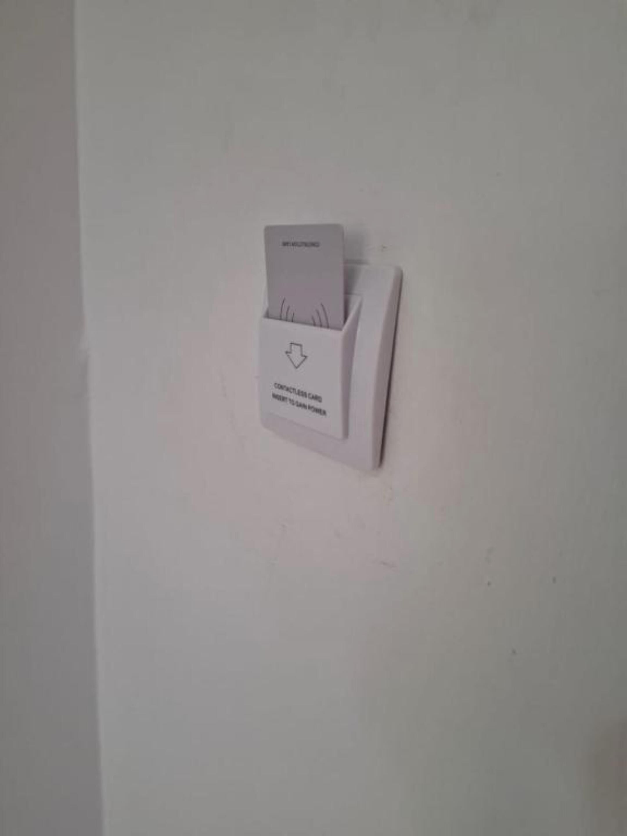 A contactless card reader mounted on a wall.