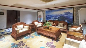 A traditional-style lobby with wooden furniture, a large mural, and a floral-patterned floor. - Jiangmen Xinhui Chenpi Redwood Hotel (Xinhui Sports Center) (Jiangmen)