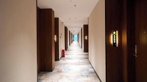 A long, narrow hotel corridor with wooden doors on both sides, a patterned floor, and a ceiling with recessed lighting. - Jiangmen Xinhui Chenpi Redwood Hotel (Xinhui Sports Center) (Jiangmen)