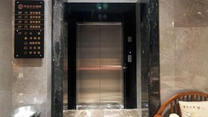 An elevator with a sign listing floor numbers and amenities. - Jiangmen Xinhui Chenpi Redwood Hotel (Xinhui Sports Center) (Jiangmen)