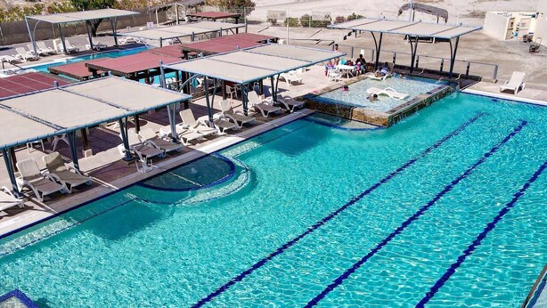 A large outdoor swimming pool with multiple lanes, sun loungers, and shaded areas. - Casa Richy - El Dorado Ranch Rental (San Felípe)