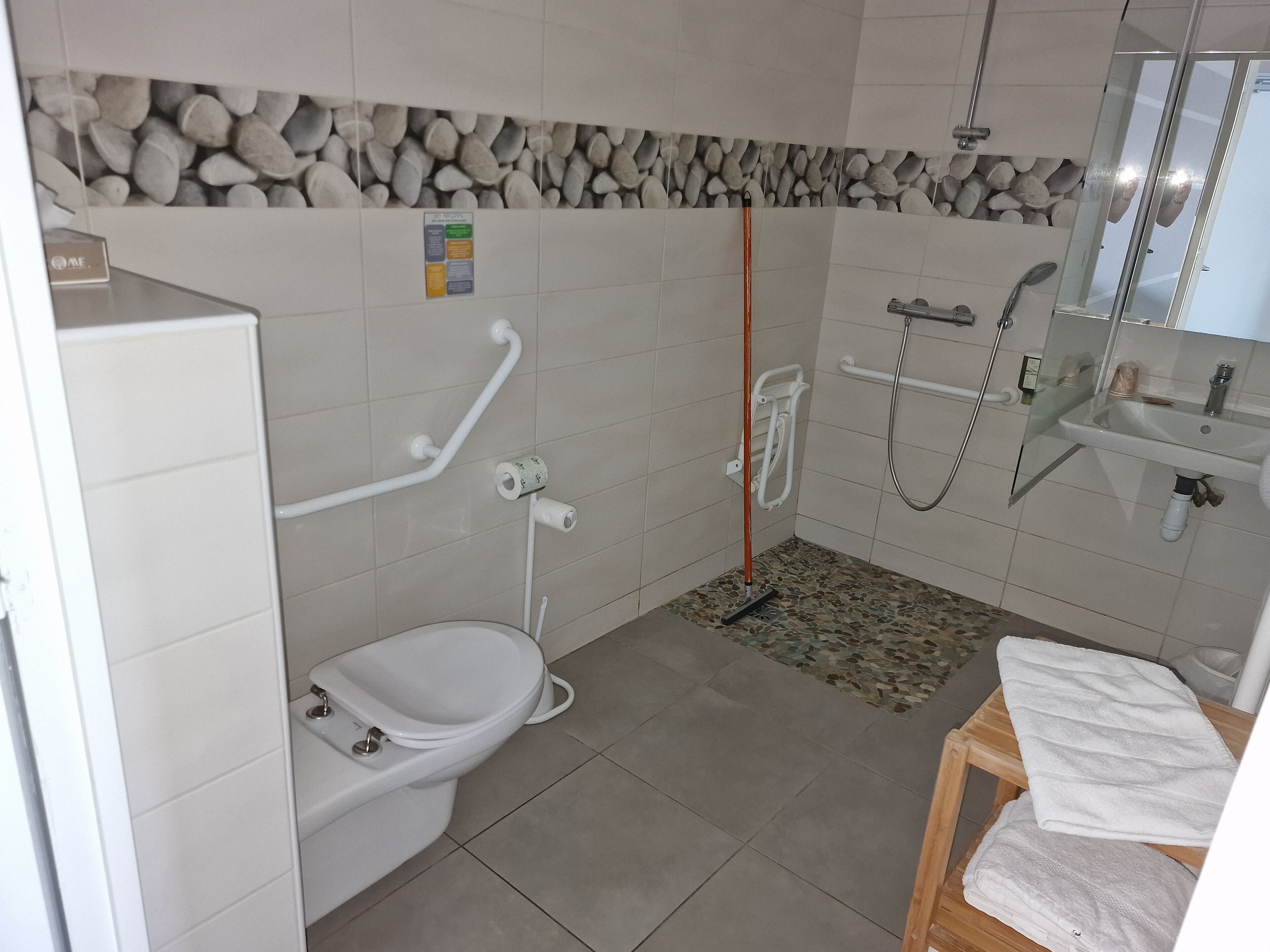 A bathroom with a toilet, a shower, and a sink.