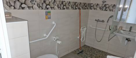 Un baño con inodoro, ducha y lavamanos.