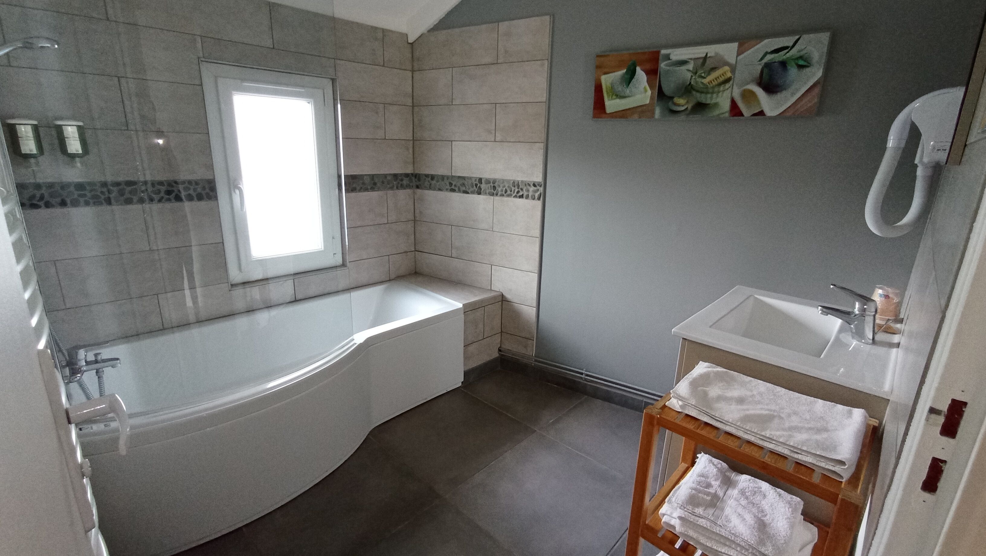 Ein Badezimmer mit Badewanne, Waschbecken und Fenster.