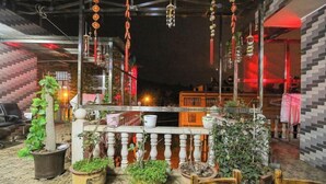An outdoor seating area with potted plants and a railing. - Shizong Donglai Inn (Shizong)