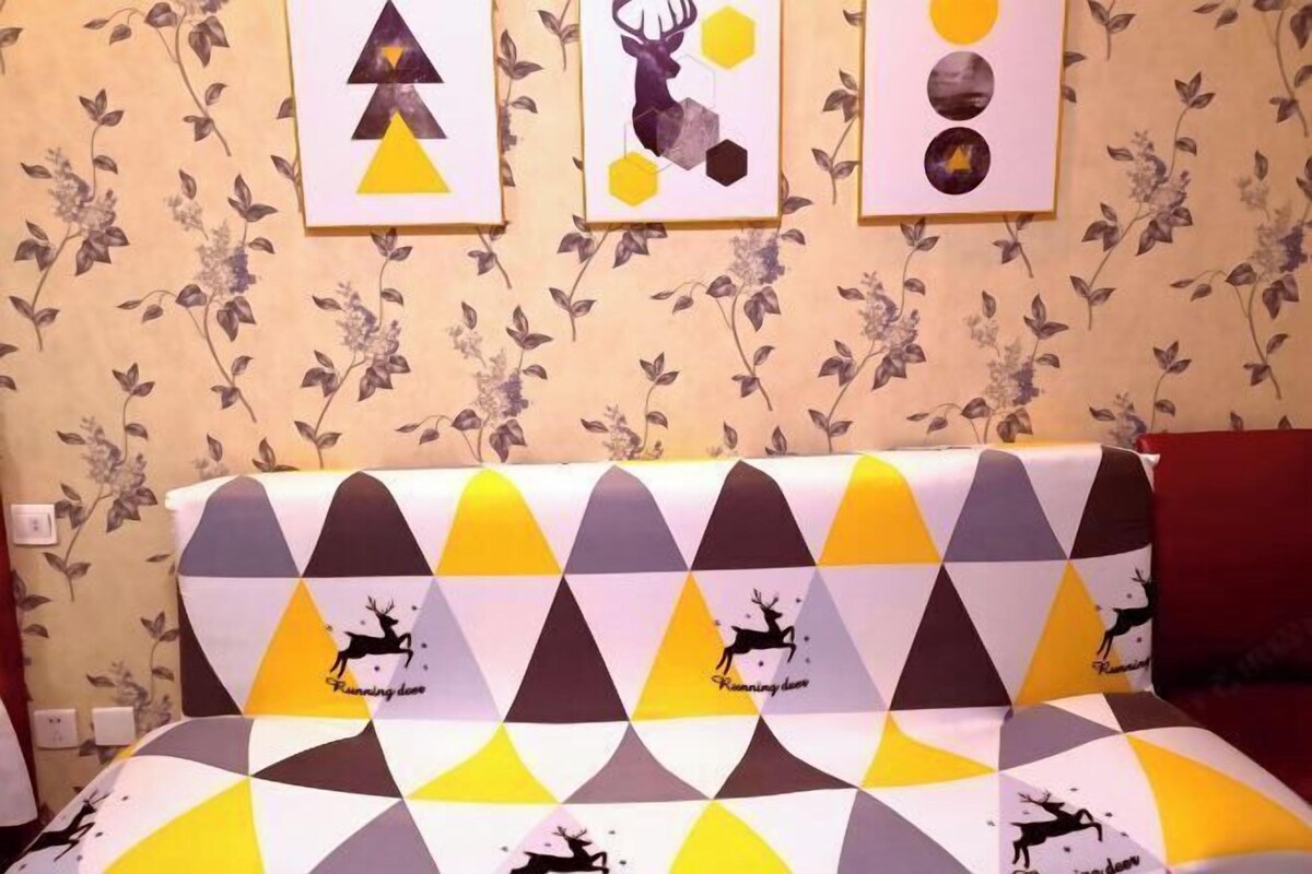 A bed with a geometric patterned bedspread featuring deer silhouettes and the text "Running deer."