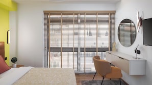 A modern bedroom with a bed, a desk, and a chair. - Aria Luxury Apartment (Patras)