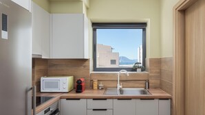 A compact kitchen with a microwave, toaster, and sink. - Aria Luxury Apartment (Patras)