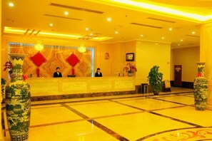 A hotel reception area with a marble floor, a reception desk, and two large vases. - Xianju Western International Hotel (Xianju)