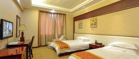 A hotel room with two beds, a desk, a TV, and a window with curtains.