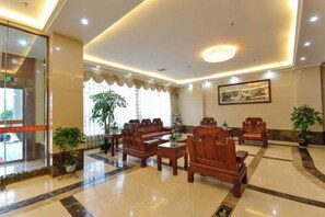 A lobby with a reception desk, seating area, and potted plants. - Xianju Western International Hotel (Xianju)