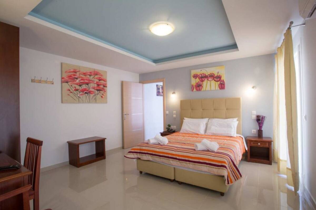 A bedroom with a bed, a desk, and a chair.