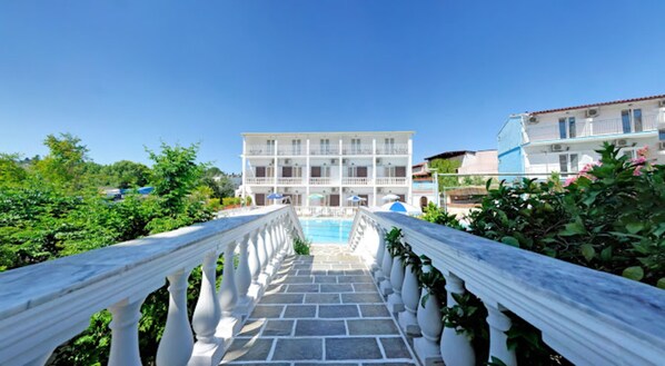 A hotel with a pool, white balustrades, and a clear blue sky. - Gouvia Hotel (Corfu)