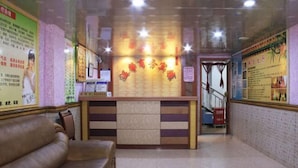 Un'area di accoglienza con reception, una sala d'attesa con divano e una scala che conduce a un piano superiore.