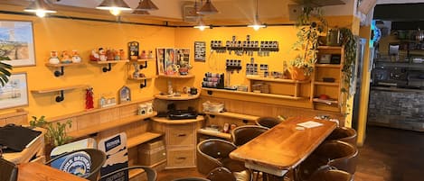 Un café acogedor con muebles de madera, lámparas colgantes y diversas decoraciones en las paredes.