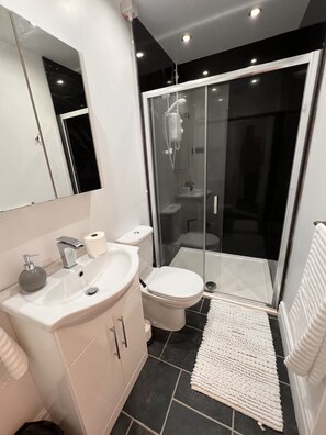 Quarto triplo superior, suíte, vista para a praia | Banheiro | Chuveiro, toalhas de banho, sabonete, shampoo