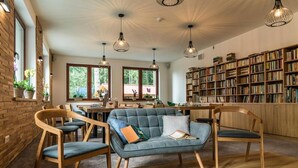 Un coin lecture confortable avec un canapé, des fauteuils et une bibliothèque.