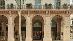 A multi-story building with a classical architectural style, featuring arched doorways and balconies with metal railings. -  Miiro Borneta (Barcelona)