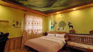 A room with a bed, a crib, a wooden ceiling, and wall decorations including a tree and animal silhouettes. - Mohe Arctic Village Time Travel Youth Hostel (Mohe)