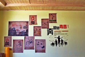 Un mur orné de nombreux affiches et sur lequel figure un motif graphique central avec du texte en chinois.