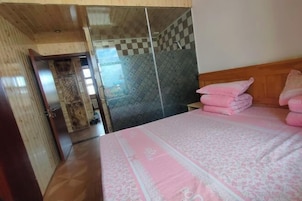 Un dormitorio con una cama, un armario de madera y una pared a cuadros.