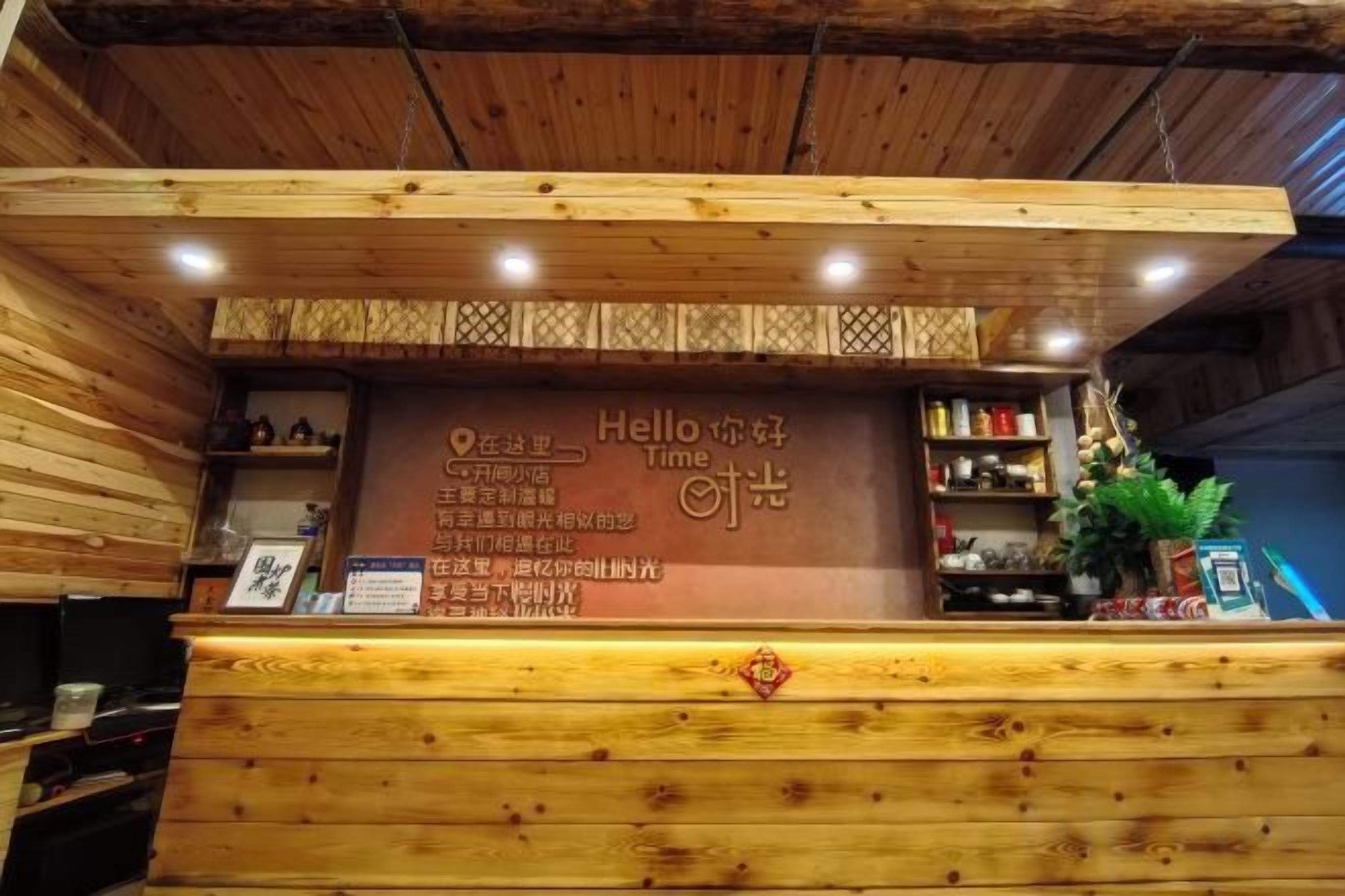 A reception desk with a wooden design, a welcome sign, and a small plant on the right.