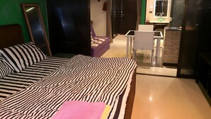 Un dormitorio con cama, una mesita y una silla.