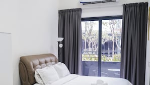 A modern hotel room with a large bed, a bedside table, a lamp, and a view of the outside. - KLIA AIRPORT HOMESTAY 5 (Sepang)