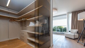 Un dormitori modern amb un vestidor, una finestra gran i una zona de seients.