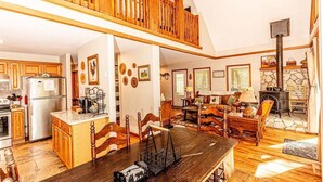 Una cocina amplia con armarios de madera, un comedor con mesa de madera y una chimenea de piedra.