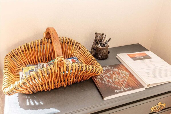Un panier en osier rempli d’en-cas et un livre d’or posés sur une table.