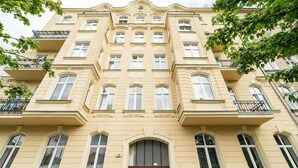 A multi-story building with a symmetrical facade, large windows, and balconies.