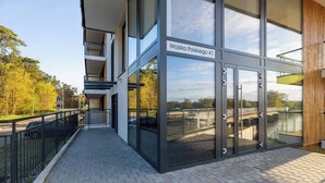 Un edificio moderno con grandes puertas de cristal y un letrero que dice 'Wojska Polskiego 41'.