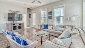 A spacious living room with a large sofa, two armchairs, a coffee table, and a television. - Newly-Renovated Beach Home with Private Pool Quick Beach Access! Slps 16 (Panama City Beach)