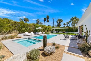 A modern outdoor pool area with lounge chairs and a cactus centerpiece. - Desert Willow-Iconic Butterfly Alexander (Palm Springs)