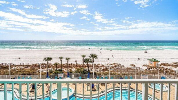 A beach view with a pool area, palm trees, and a lifeguard tower. - Peaceful Beach Paradise (Panama City Beach)