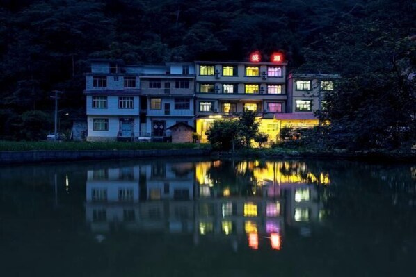 Stunning lakefront building with multiple windows and balconies, offering serene views of the surrounding natural landscape.
