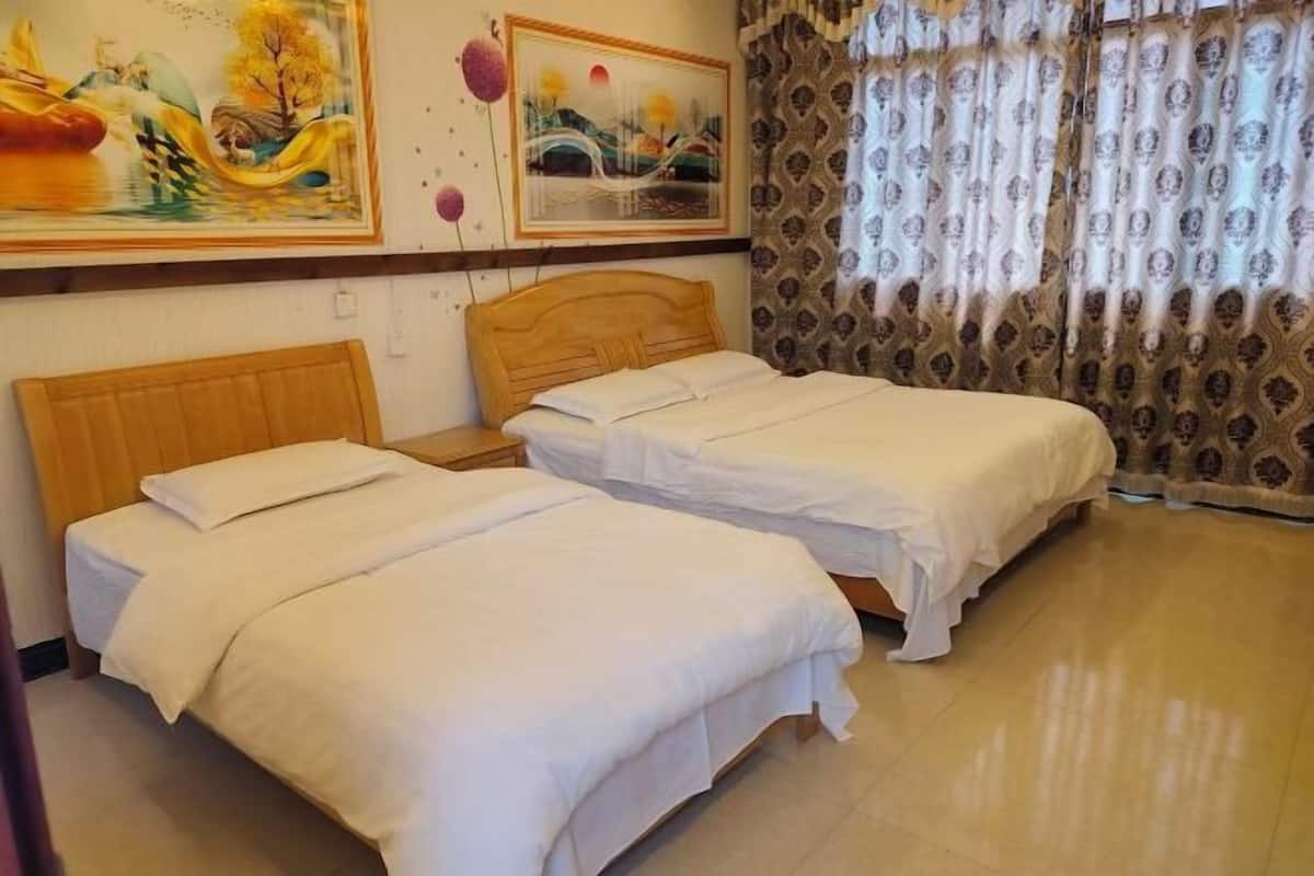 Habitación de hotel con dos camas individuales, cabecera de madera y un cuadro grande en la pared.