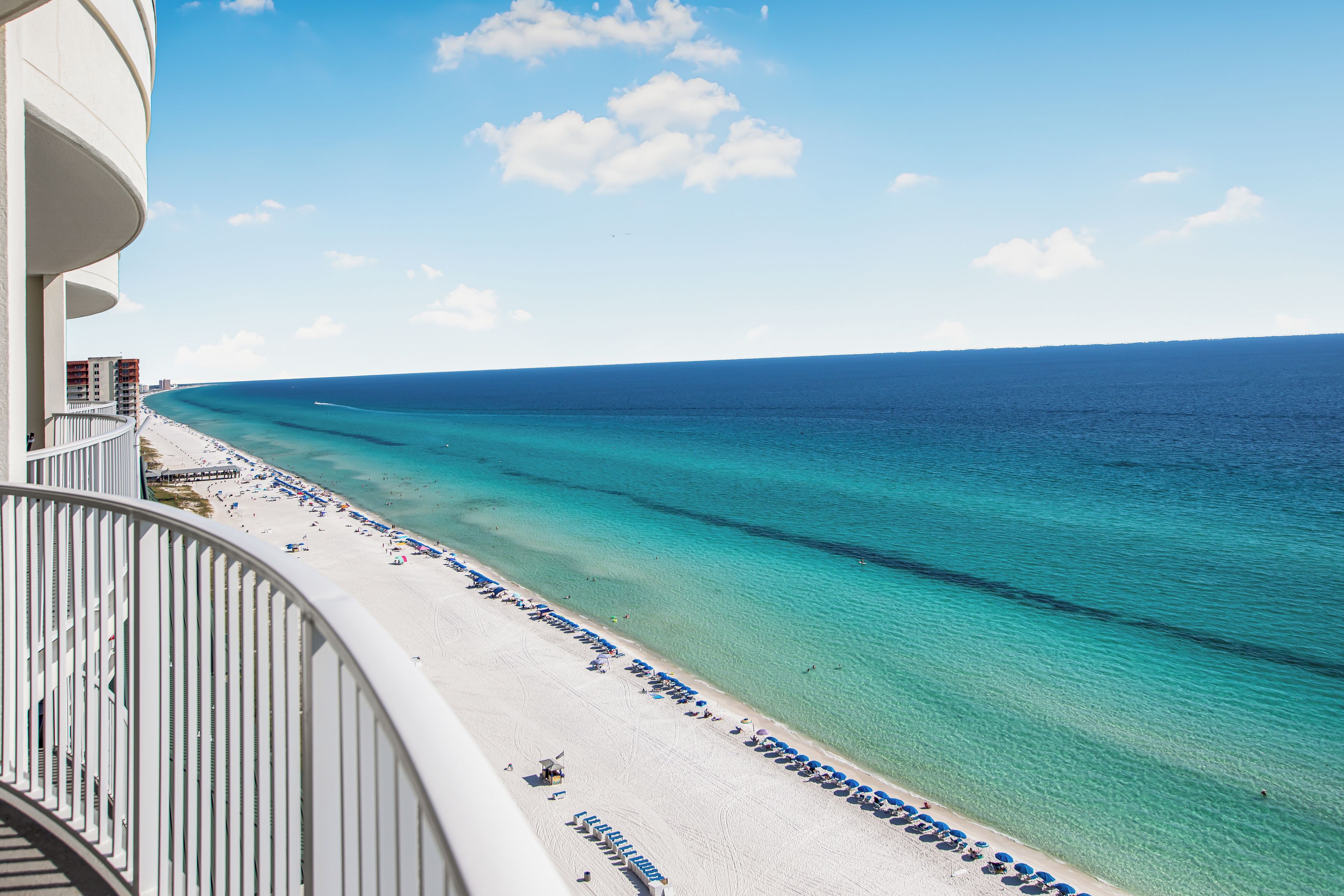 A balcony with a view of a beach and ocean.