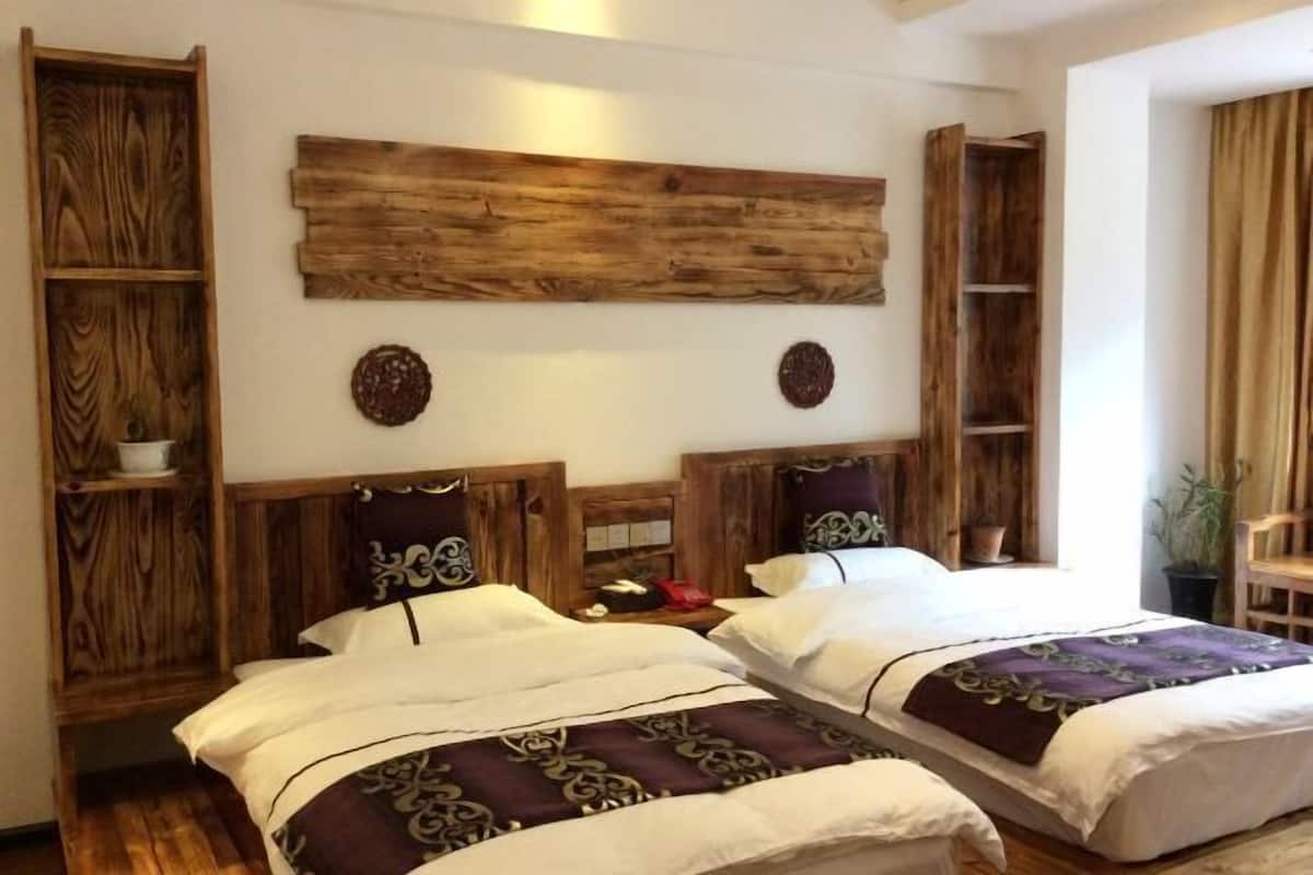 A double room with two beds, wooden headboards, and a large wooden panel above the beds.