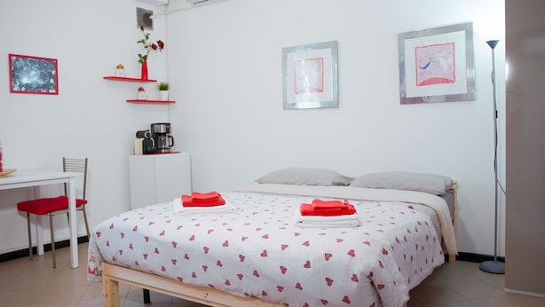 Ein Schlafzimmer mit einem Bett, einem Schreibtisch, einem Stuhl und einer Kaffeemaschine.