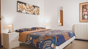 A bedroom with a bed, nightstands, a mirror, and artwork on the walls. - 1 Bed-sleeps 4-town Centre-free Parking-aircon (Montagnana)