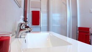 A modern bathroom with a white sink, chrome faucet, and a glass of red liquid. - 1 Bed-sleeps 4-town Centre-free Parking-aircon (Montagnana)