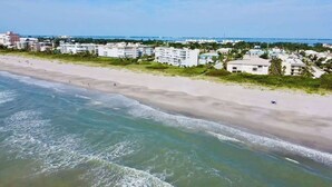 A coastal hotel with beachfront access, multiple stories, and a view of the ocean.