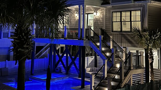 Une maison à plusieurs étages dotée d’une piscine, de balcons et d’un escalier.