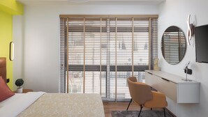 A modern bedroom with a bed, a desk, and a chair. - Aria Luxury Apartment  (Patras)