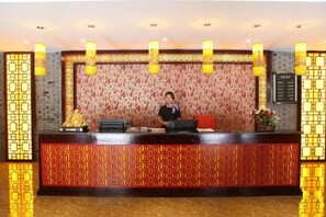 Un taulell de recepció amb un fons estampat i una recepcionista.