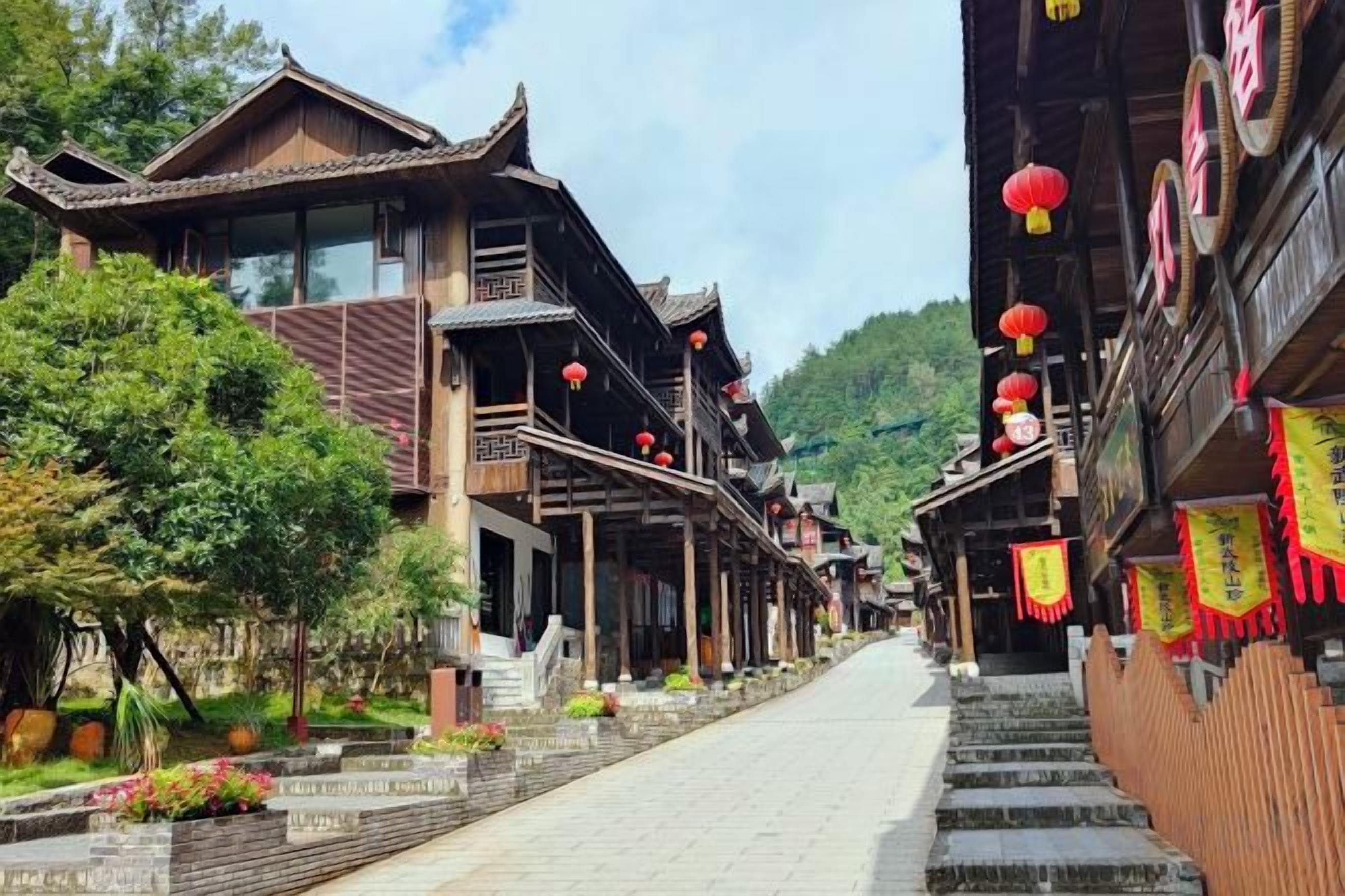 A traditional street with wooden buildings, a paved walkway, and red lanterns.