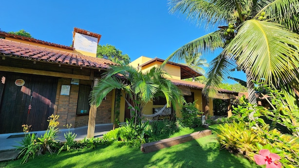 A traditional building with a tiled roof and a sign reading "CASA DOURADA POUSA". - Pousada Cais Dourado (Maraú)